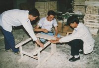 Three students put together a school desk. The shop has already made 500 desks with stools for the other schools in Shandan, as well as beds, cabinets and other pieces of furniture.