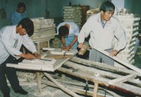 Vice-Principal Wang Zigang tries his hand with a Chinese plane. (Note traditional Chinese crosscut saw in foreground).