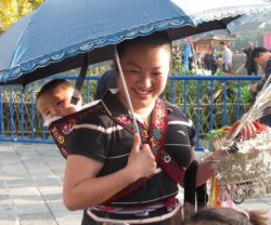 Miao mother and baby in an embroidered back pack
