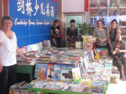 Display of Kiwi books provided to Bazhong Primary School.   Rosey Long, Emily next to John He with Rapanui