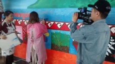 Students working on the mural (being filmed)