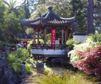pagoda with a red banner among a pond and bushes