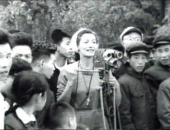 Group of people around a woman with a camera