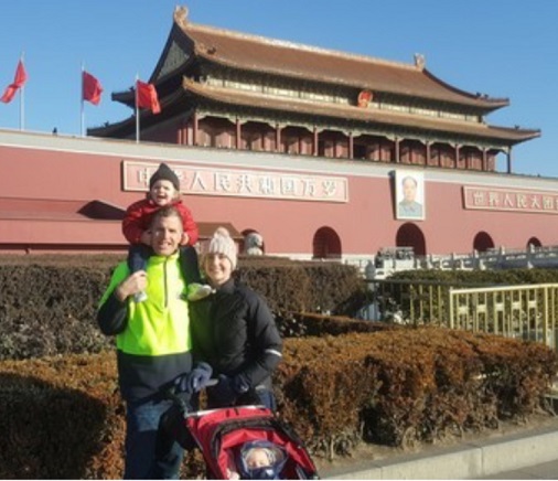 a man woman and child standing outside of a Chinese architectured building
