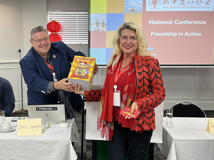 NZCFS Auckland Branch Vice President Galina May receives a raffle prize at 2023 National Conference and AGM.